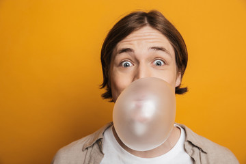Funny handsome man in shirt eating bubble gum