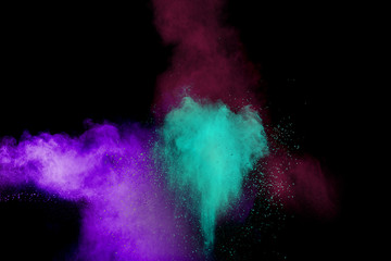 Throw color powder on dark background.Explosion of colored powder isolated on black background.