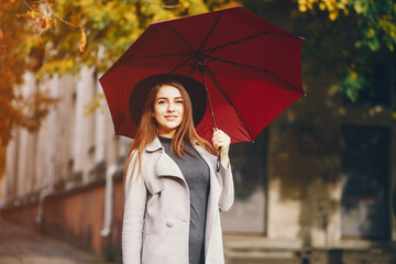 beautiful elegant girl walking around the autumn city with umbrellas