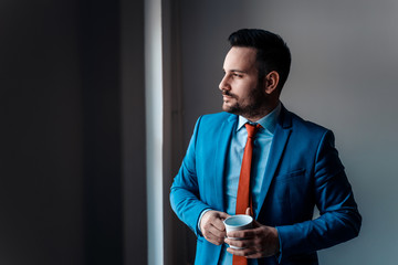 Portrait of confident businessman looking through window.