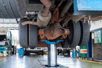 mechanic works with rear axle reduction gear of truck maintenance shop service station - Truck Service Technician Job. - obrazy, fototapety, plakaty