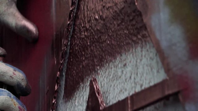 Hand with a spray can painting graffiti.