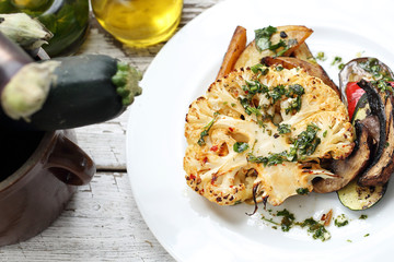 Vegetarian cooking. Baked cauliflower with mushrooms served with herbs.