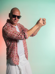 attractive man with colorful shirt on green and orange background in photo studio