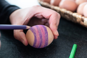 Eggs decoration, children is coloring an ester egg. Coloring eggs with pastel creativity activities...