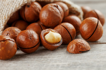 Macadamia nut on a wooden table in a bag, closeup, top view