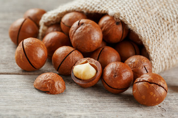 Macadamia nut on a wooden table in a bag, closeup, top view
