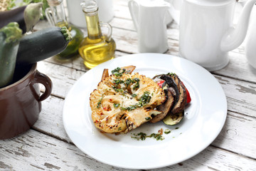 Vegetarian dish.  Baked cauliflower with mushrooms served with herbs.