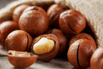 Macadamia nut on a wooden table in a bag, closeup, top view