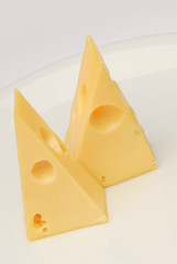 Cheese slice isolated on gray background cutout on a plate