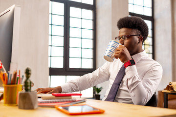 Pleasant young man taking a sip of tea