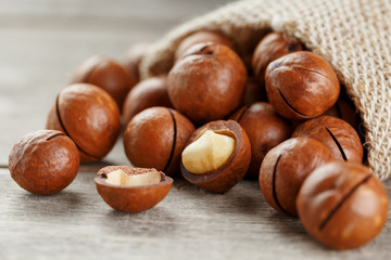 Macadamia nut on a wooden table in a bag, closeup, top view