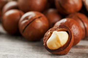 Macadamia nut on a wooden table in a bag, closeup, top view