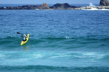 無人島に向けて波を越えて進むシーカヤック