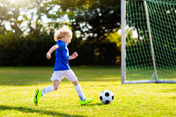 Kids play football. Child at soccer field.