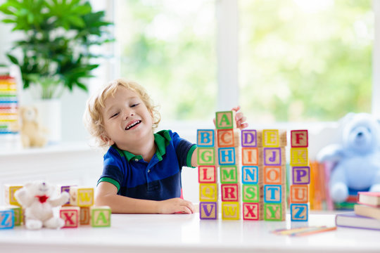 Child Learning Letters. Kid With Wooden Abc Blocks