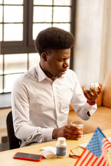 Nice handsome man looking at the bottle with pills