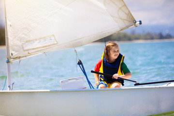 Child sailing. Kid learning to sail on sea yacht.