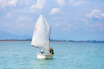 Child sailing. Kid learning to sail on sea yacht.
