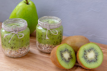 Kiwi smoothie with cereal on a wooden table.