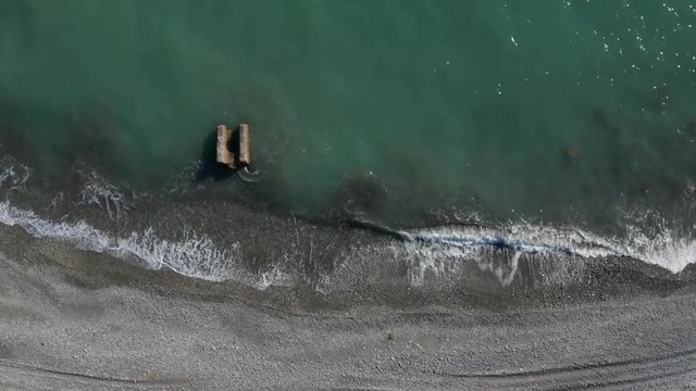 Aerial photography from a bird's-eye drone. The camera shoots down. sea surf. Turquoise wave. The surf of the sea. The black sea coast of Sochi. The view from the top. Breakwater