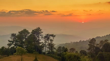 Fototapeta na wymiar Mountain view evening of Top hill around with soft fog with yellow and red sun light in the sky background, sunset at Huai Nam Dang National Park, Chiang Mai, Thailand.