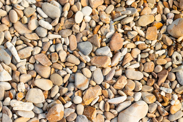 Stone gravel, beach area stone gravel several colors and coral fragments at have shape rounded round caused because of sea waves make give objects bump together all the time cause beauty naturally.