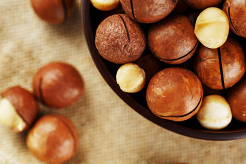 Macadamia nut on wooden background with vintage cloth, concept of superfoods and healthy food