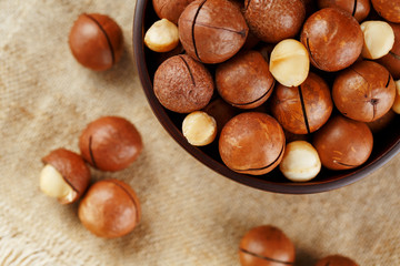 Macadamia nut on wooden background with vintage cloth, concept of superfoods and healthy food
