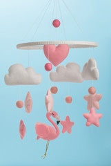 Colorful and eco-friendly children's mobile from felt for children. On blue background.