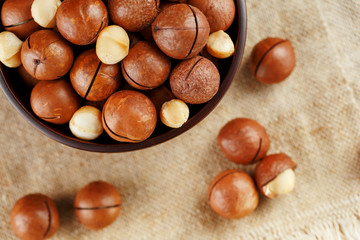 Macadamia nut on wooden background with vintage cloth, concept of superfoods and healthy food