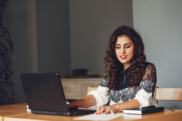 Beautiful girl in the office. Woman is working. A woman with curly hair