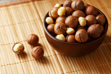 Macadamia nut on bamboo texture, concept of superfoods and healthy food