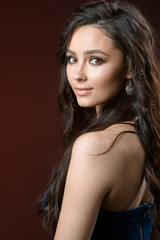 Fototapeta premium jewelry and fashion concept. A model with earrings necklace and ring on brown background