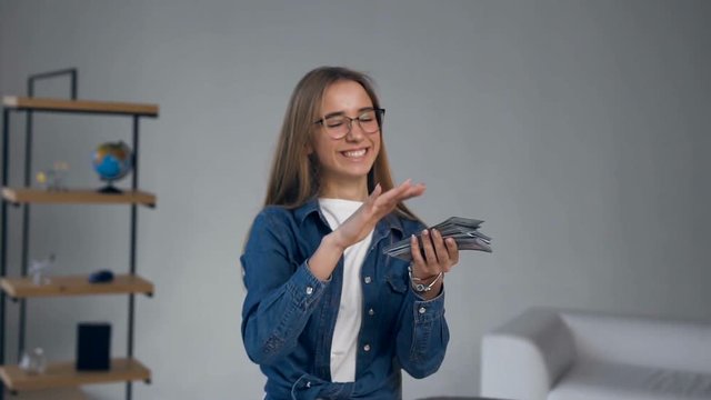 Handsome smiling woman throwing money for travel.