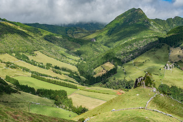 A green mountain landscape with a spectacular valley surrounded by peaks. Taken on the island of Flores in the Azores.