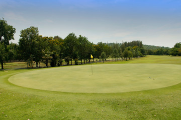 The evening golf course has sunlight shining down at golf course in Thailand