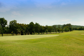 The evening golf course has sunlight shining down at golf course in Thailand