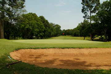 The evening golf course has sunlight shining down at golf course in Thailand