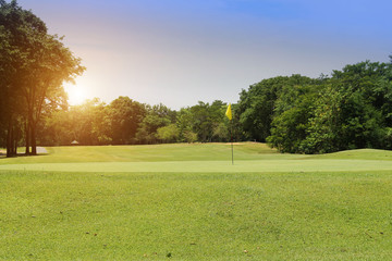 The evening golf course has sunlight shining down at golf course in Thailand