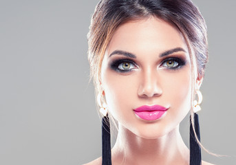 Beauty brunette woman with makeup earrings and beautiful hairstyle beauty lipsa and lashes eyes...