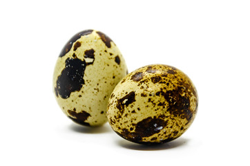 Two small quail eggs in a brown speck isolated on a white background