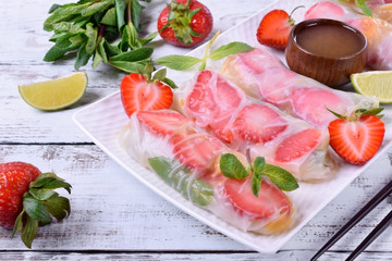 Spring rolls with strawberry, fruits and sauce. Vietnamese cuisine snack