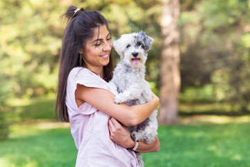 Beautiful Smiling Woman Hugging  Her Cute Havanese Dog .Pet and Owner Outdoor