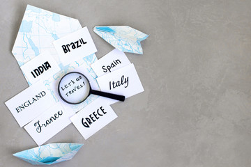 lets go travel text, country selection, map, magnifier, compass, gray background