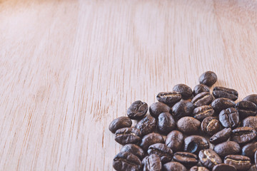 Close up of Coffee beans on wood background in vintage tone color style, selective focus (detailed close-up shot)