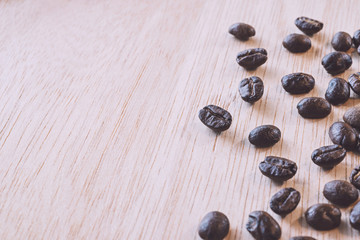 Close up of Coffee beans on wood background in vintage tone color style, selective focus (detailed close-up shot)