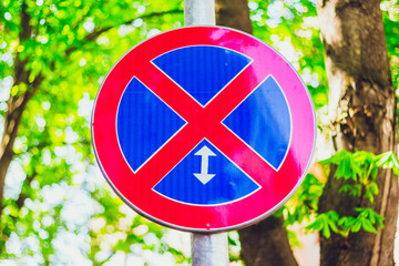 Circle sign with red cross on a blue background – Traffic symbol that prohibits parking and stopping the car on a section of road