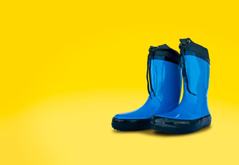 Blue rubber boots isolated	on yellow background