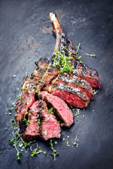 Traditionell gegrilltes dry aged Wagyu Tomahawk Steak aufgeschnitten mit Salz und Kräuter als...
